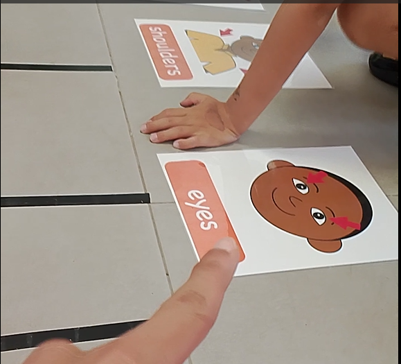 Niños identificando las partes del cuerpo en inglés con tarjetas ilustradas